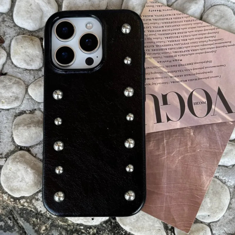 Black phone case with silver studs on a magazine cover